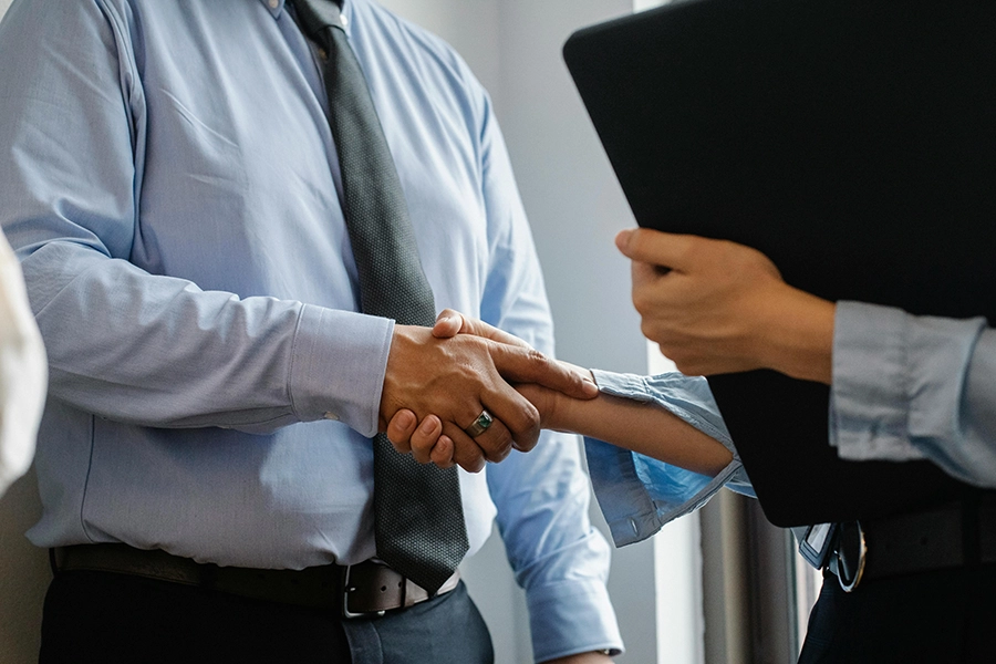 Business professionals shaking hands after partnership agreement with web application development project